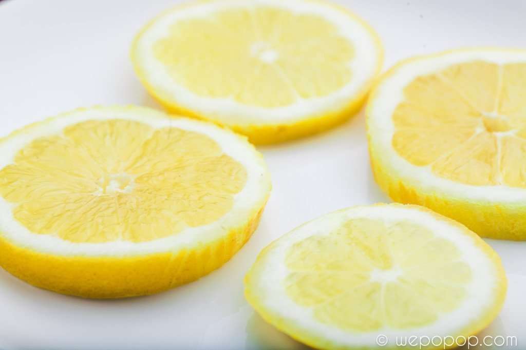 Fyra citronskivor på en tallrik till citron- och ingefärspopcorn
