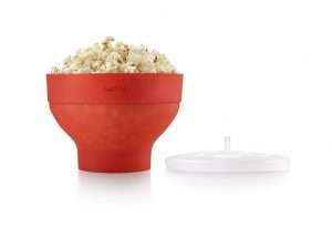 En micropopcornskål full av poppade popcorn med ett lock bredvid