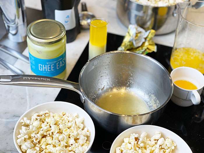 Burk med ghee och smält ghee i kastrull