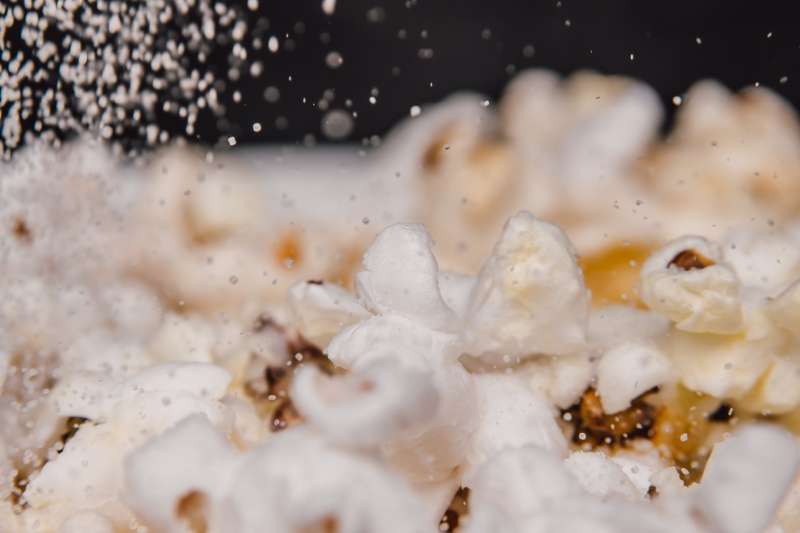 Salt strös över nypoppade popcorn